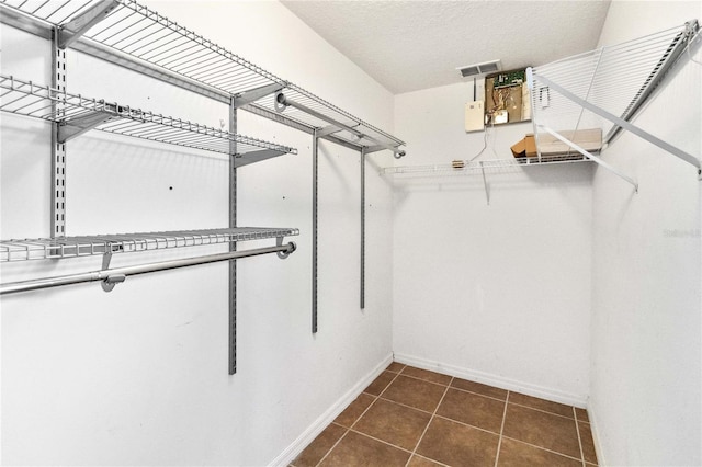 walk in closet featuring dark tile patterned floors