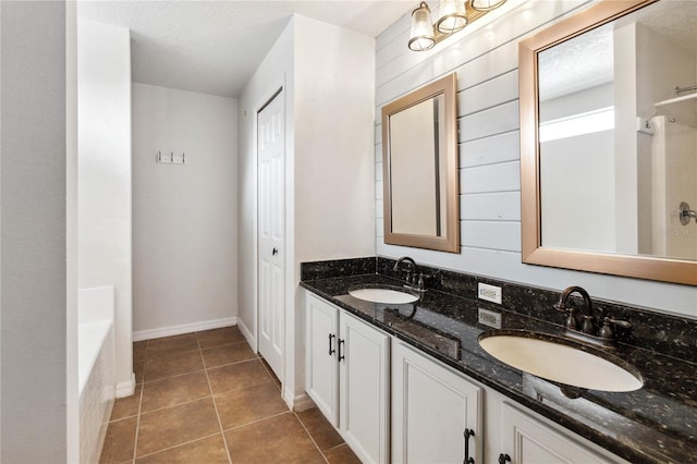 bathroom with vanity, tile patterned floors, a textured ceiling, and a tub to relax in