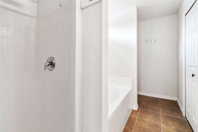 bathroom with tile patterned flooring and a tub