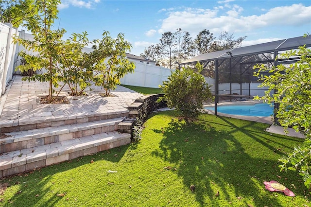 view of yard with a fenced in pool, a patio, and glass enclosure