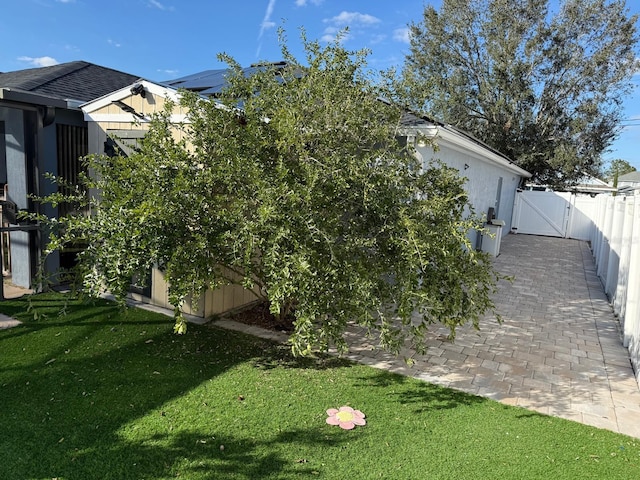 view of side of home featuring a yard and a patio