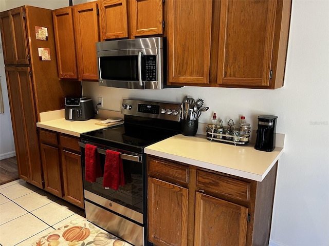 kitchen featuring light tile patterned floors and stainless steel appliances