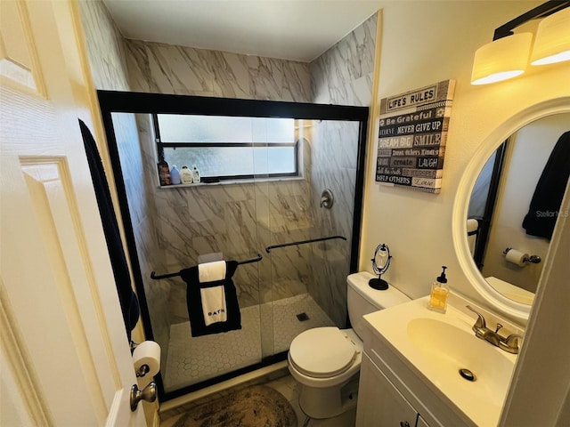 bathroom featuring an enclosed shower, vanity, and toilet