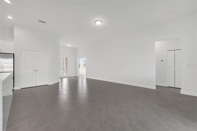 unfurnished living room with dark tile patterned floors