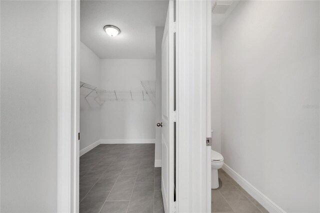 walk in closet with light tile patterned floors