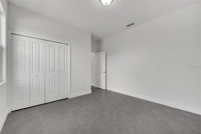 unfurnished bedroom featuring tile patterned floors and a closet