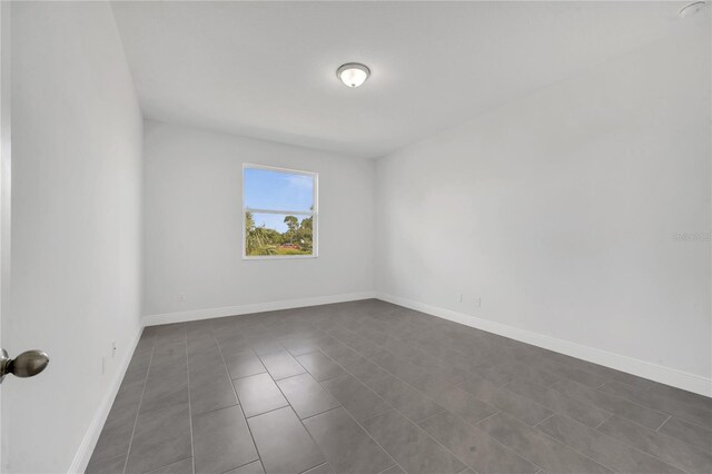 empty room with dark tile patterned floors