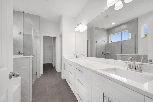 bathroom with tile patterned floors, vanity, and a shower with door