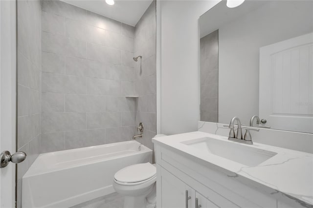 full bathroom with vanity, tiled shower / bath combo, and toilet