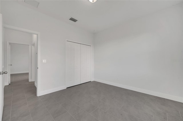 unfurnished bedroom with tile patterned floors and a closet