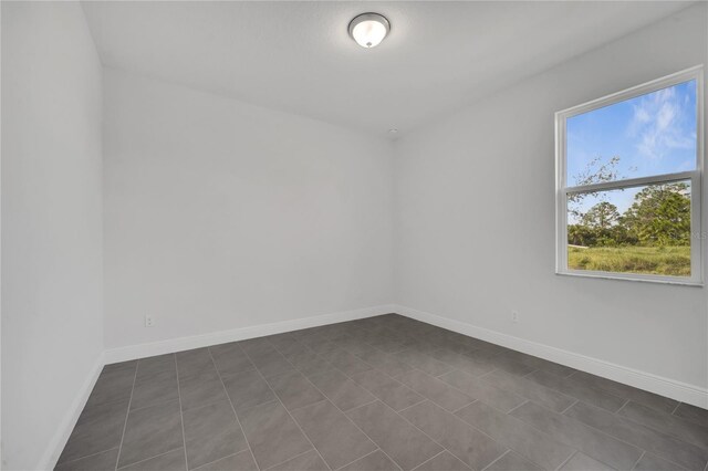 empty room with dark tile patterned floors