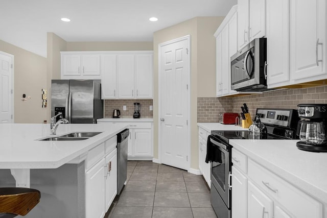 kitchen with white cabinetry, sink, stainless steel appliances, and dark tile patterned flooring