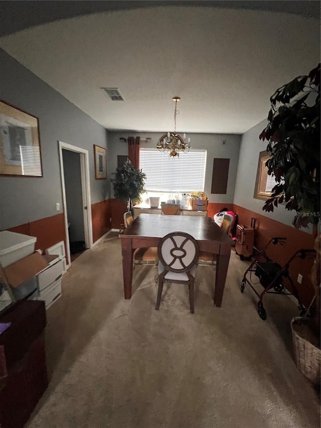 dining area featuring carpet flooring and a notable chandelier