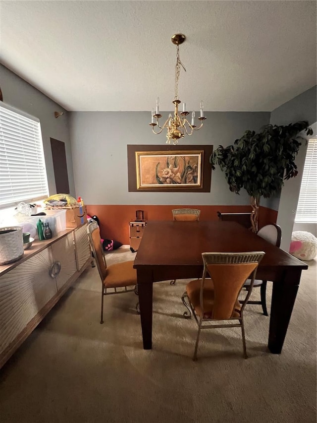 carpeted dining area featuring a chandelier