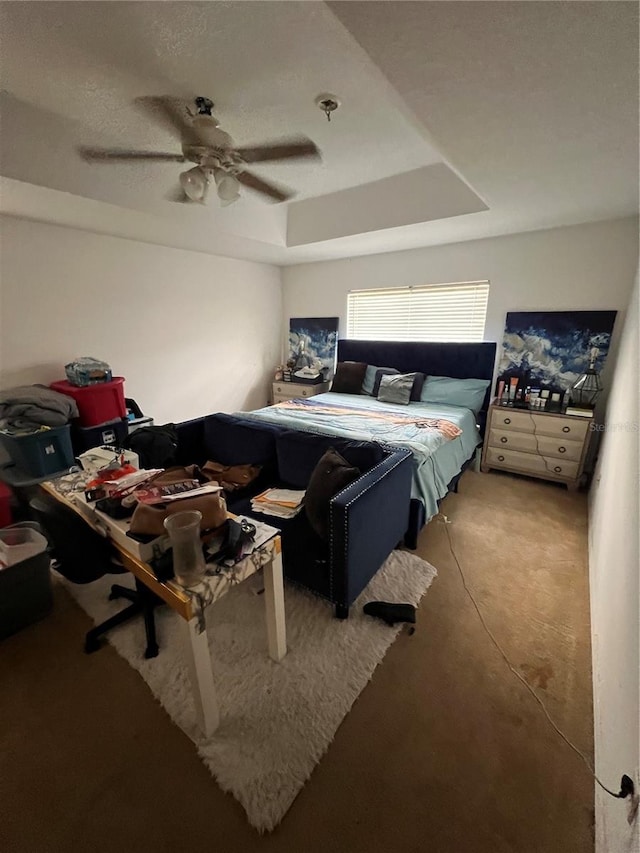 bedroom with ceiling fan and a tray ceiling