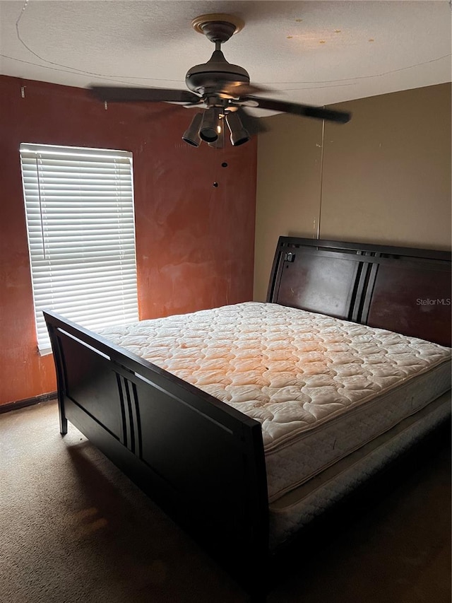 bedroom featuring carpet flooring, a textured ceiling, and ceiling fan