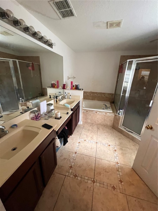 bathroom with tile patterned floors, vanity, shower with separate bathtub, and a textured ceiling