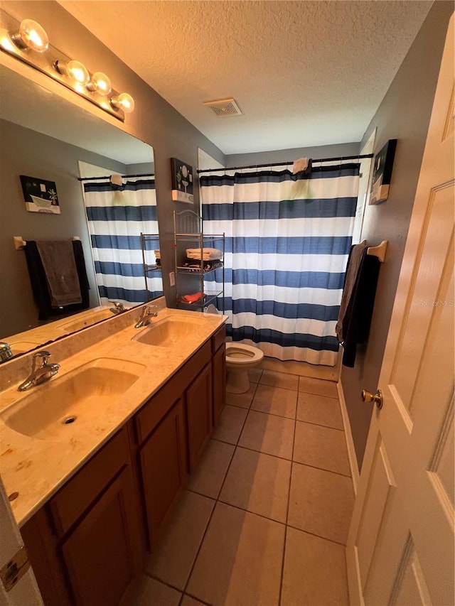 bathroom with vanity, tile patterned flooring, a shower with shower curtain, toilet, and a textured ceiling