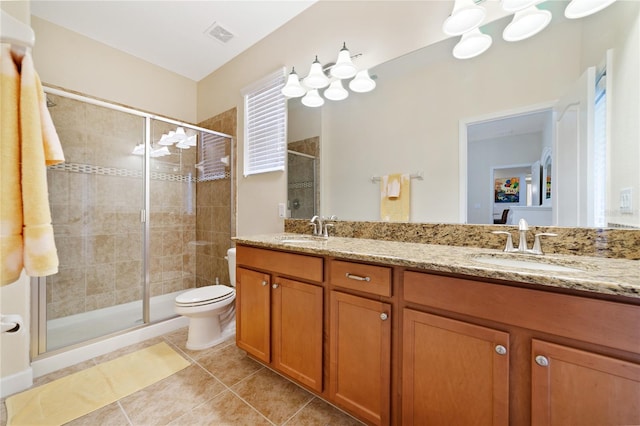 bathroom featuring tile patterned flooring, vanity, toilet, and a shower with shower door