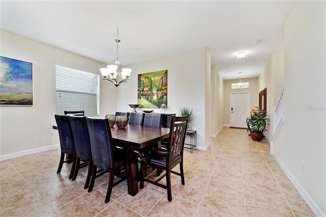 tiled dining room with an inviting chandelier