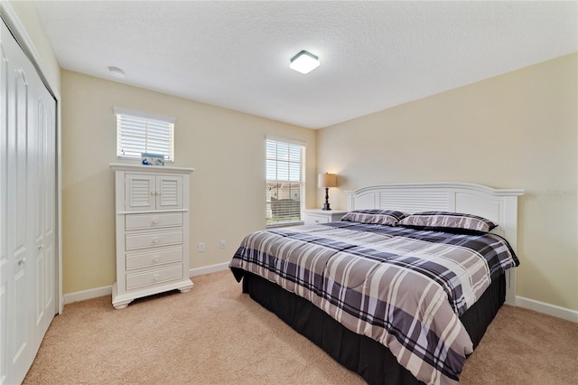 carpeted bedroom featuring a textured ceiling and a closet