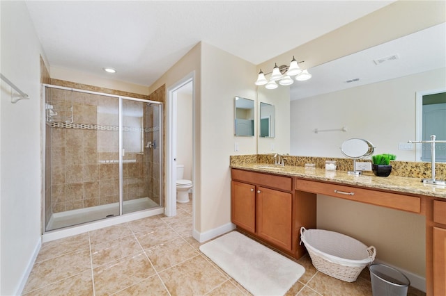 bathroom featuring tile patterned flooring, vanity, toilet, and a shower with door