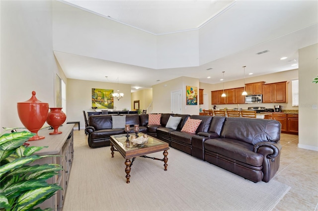 living room featuring light tile patterned flooring, a high ceiling, and an inviting chandelier