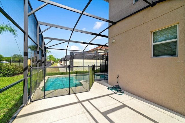 view of pool featuring a jacuzzi, glass enclosure, and a patio area