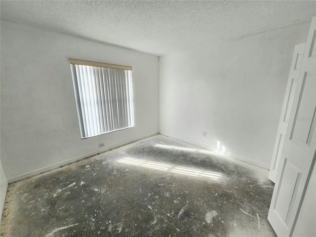 unfurnished room featuring a textured ceiling