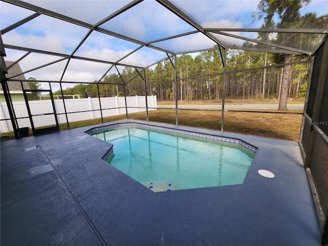 view of swimming pool with glass enclosure and a patio area