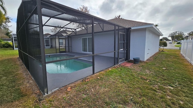 back of house featuring glass enclosure and a lawn