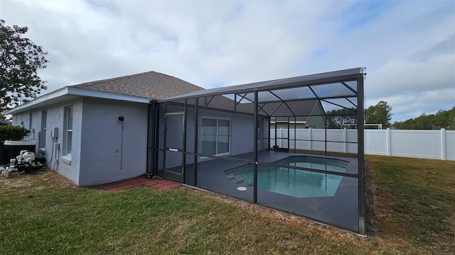 back of property with a yard, a fenced in pool, and a lanai