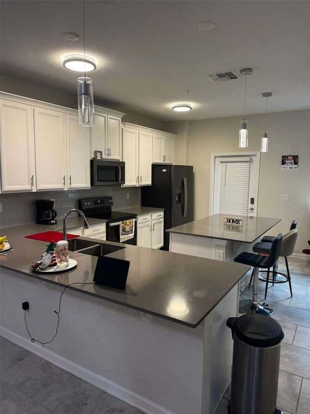 kitchen with stainless steel appliances, a kitchen island, a kitchen breakfast bar, pendant lighting, and white cabinets