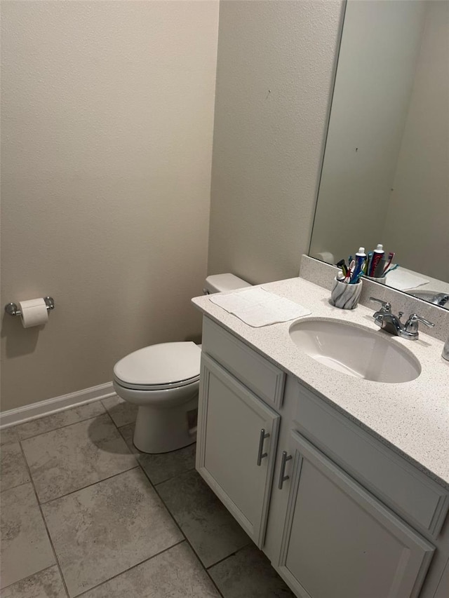 bathroom featuring tile patterned flooring, vanity, and toilet