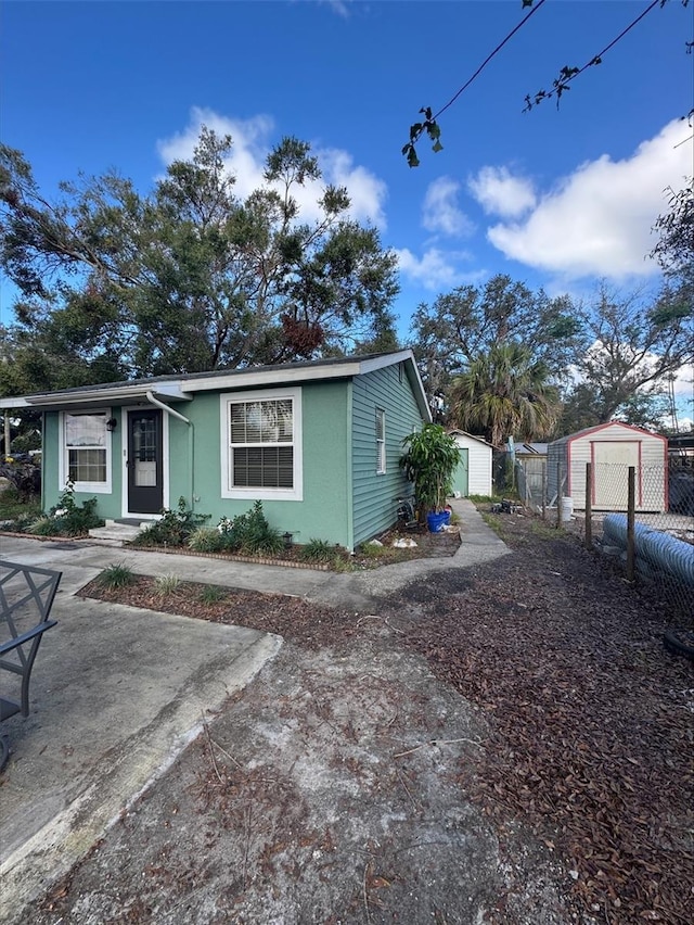 view of front of property featuring a shed