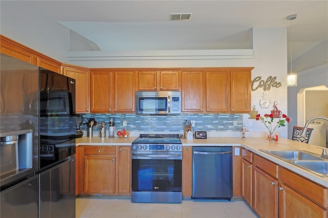 kitchen with backsplash, light tile patterned flooring, decorative light fixtures, and appliances with stainless steel finishes