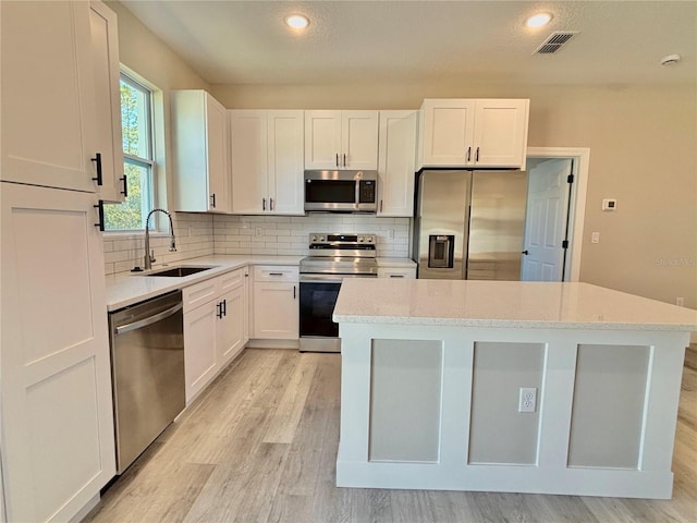 kitchen with white cabinetry, light stone countertops, sink, and appliances with stainless steel finishes