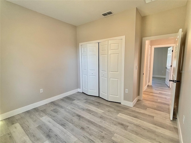 unfurnished bedroom featuring light hardwood / wood-style floors and a closet