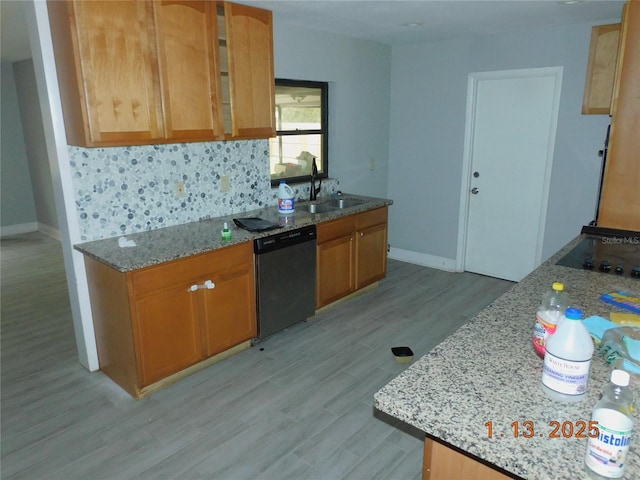 kitchen featuring dishwasher, tasteful backsplash, light stone counters, and sink