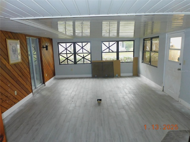 interior space with wood-type flooring and wooden walls