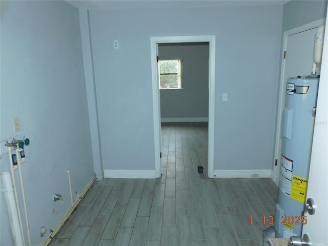 spare room with water heater and light hardwood / wood-style flooring