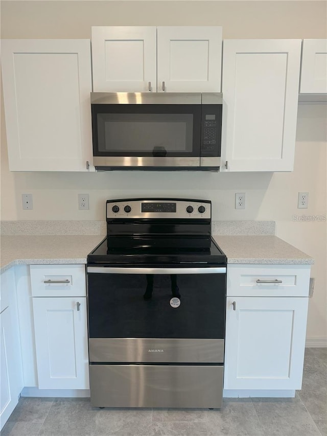 kitchen with appliances with stainless steel finishes and white cabinetry