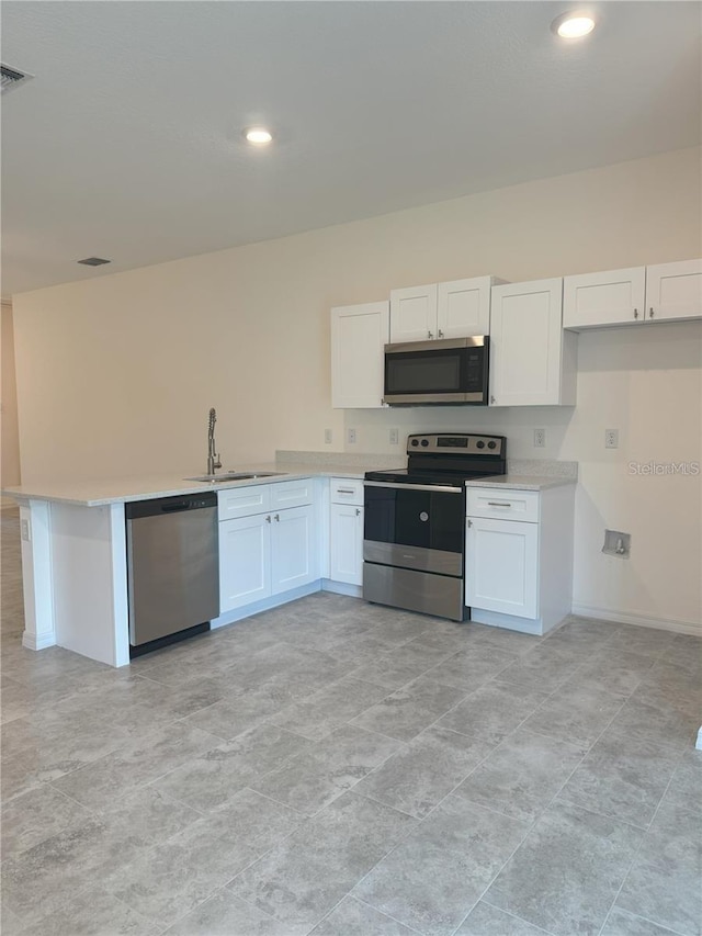 kitchen featuring kitchen peninsula, white cabinetry, sink, and stainless steel appliances