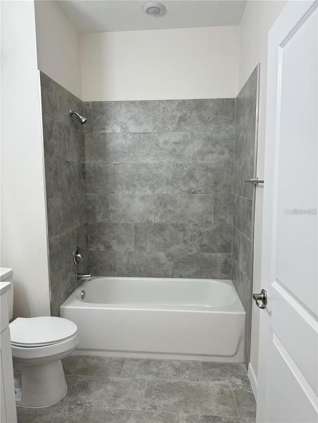 full bathroom featuring tiled shower / bath combo, toilet, and vanity