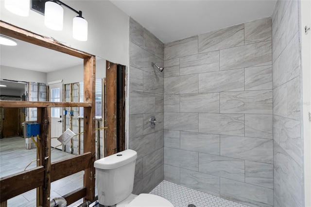 bathroom featuring toilet and a tile shower