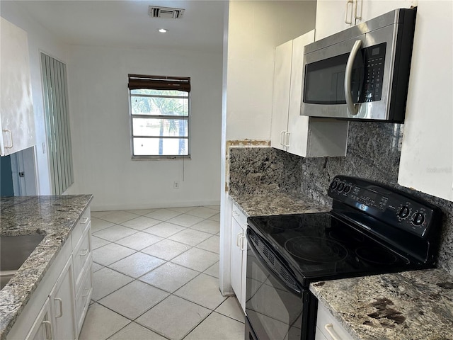 kitchen with white cabinetry, black range with electric cooktop, light stone counters, decorative backsplash, and light tile patterned floors