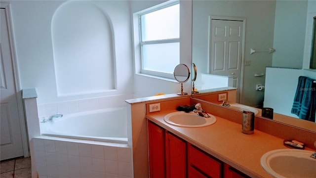 bathroom featuring tiled bath, tile patterned floors, and vanity