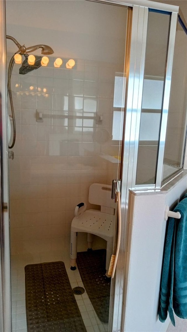 bathroom featuring a shower with shower door, tile walls, and tile patterned floors