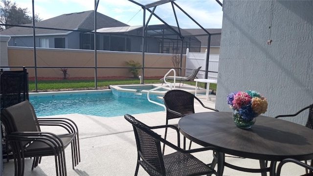 view of pool with a lanai, a patio area, and an in ground hot tub