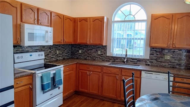 kitchen with dark wood-type flooring, sink, backsplash, and white appliances